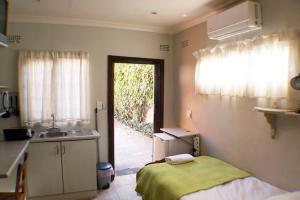 uma cozinha com uma cama, um lavatório e uma janela em A Place of Grace em Durban