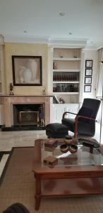 uma sala de estar com uma lareira, uma cadeira e uma mesa em El olivo em Tordesilhas
