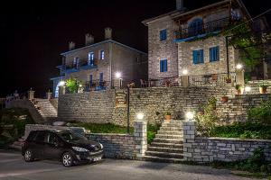een auto die 's nachts voor een gebouw geparkeerd staat bij Hotel Ladias in Monodendri
