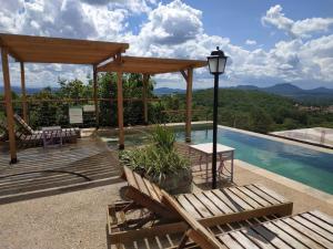 um pátio com uma mesa, um candeeiro e uma piscina em Serra do Juá Pousada de Campo em Pirenópolis