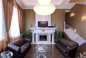 Una sala de estar con sofás de cuero y chimenea. en Отель Корона, en Dnipro
