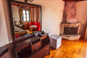 a living room with a dresser and a mirror at Hotel Ladias in Monodendri