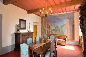 une salle à manger avec une table et un tableau mural dans l'établissement Palazzo Tombesi Trecci, à Montepulciano