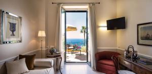 un soggiorno con divano e porta scorrevole in vetro di Hotel Villa Belvedere a Taormina