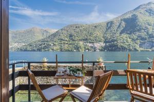 uma mesa e cadeiras numa varanda com vista para um lago em Your Private Harbour on Lake Como by Rent All Como em Laglio