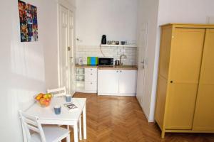 een keuken met een witte tafel en een gele kast bij Corner 3 I Old Town I Studio in Krakau