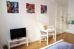 een woonkamer met een televisie en een tafel met een stoel bij Corner 3 I Old Town I Studio in Krakau