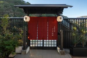 a gate with a red curtain on it at Onsen Guest House Tsutaya in Hakone