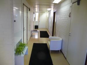 a hallway of an office building with a chair and plants at Majatalo Villanen in Längelmäki