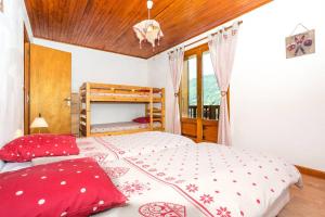 ein Schlafzimmer mit einem großen Bett mit roten Kissen in der Unterkunft Piste B in Morzine