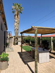 a patio with a table and a palm tree at Keetmanshoop Self-catering in Keetmanshoop