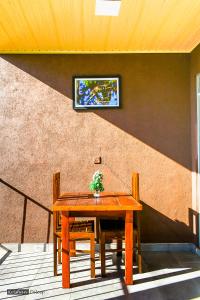 a wooden table with two chairs and a television on a wall at Will Guest Homestay in Ella