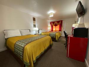a hotel room with two beds and a flat screen tv at Motel West in Bend