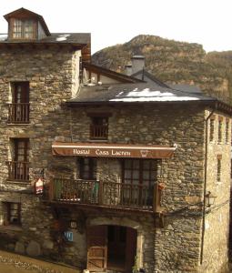 un antiguo edificio de piedra con balcón. en Hostal Casa Lacreu en Sahun