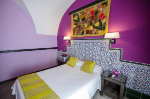 a bedroom with a bed and a painting on the wall at La Flor De Al-Andalus in Mérida +29 photos