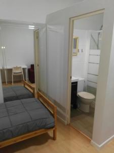 a bedroom with a bed and a toilet and a mirror at Estudios Cientouno in Las Lagunas