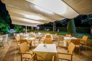 ein Restaurant mit Tischen, Stühlen und einem Sonnenschirm in der Unterkunft Elia Hotel in Buccino