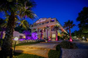 ein Gebäude mit Palmen und violetten Lichtern in der Unterkunft Elia Hotel in Buccino