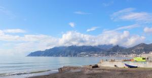 a view of a beach with mountains and the water at SEAFRONT APARTMENT SALERNO in Salerno