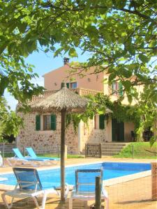 a house with a pool and two chairs and an umbrella at Finca Maravillosa Vista in Campos
