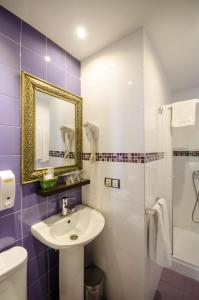 Un baño con lavabo, inodoro y espejo. en La Flor De Al-Andalus, en Mérida