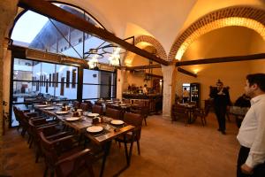 a dining room with a long table and some people at Yazmacılar Hanı Otel Restaurant in Tokat