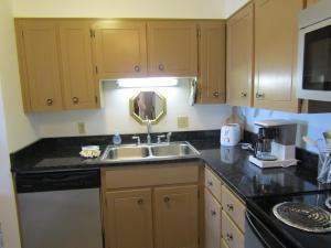 Una cocina con gabinetes de madera y un fregadero. en Cozt Downstairs Skyleaf D1 Condo, en Sugar Mountain 9 fotos más