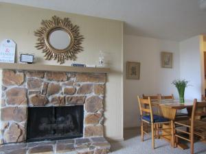 sala de estar con chimenea de piedra y espejo en Cozt Downstairs Skyleaf D1 Condo, en Sugar Mountain