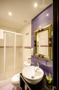 a bathroom with a sink and a toilet and a mirror at La Flor De Al-Andalus in Mérida