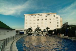 a hotel with a swimming pool in front of a building at Sanha Plus Hotel in Santa Marta