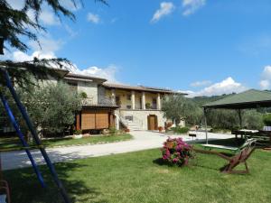 uma casa com um quintal com um baloiço em Agriturismo La Rocca Assisi em Petrignano