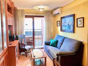 ベニドルムにあるSanto Domingo Apartmentのリビングルーム(青いソファ、窓付)