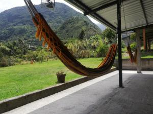 un'amaca in veranda con vista sulle montagne di Montano Camping & Hostel a Baños