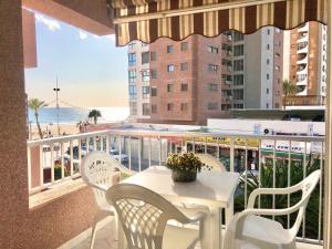 stół i krzesła na balkonie z widokiem na plażę w obiekcie Los Ranchos Blueline w mieście Benidorm