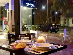 a table with plates of food and candles on it at Hotel Azul by MH in Punta del Este