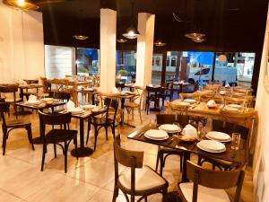 a restaurant with wooden tables and chairs and a large window at Hotel Azul by MH in Punta del Este