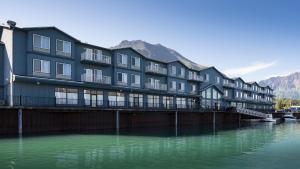 a large building next to a body of water at Harbor 360 Hotel Seward in Seward
