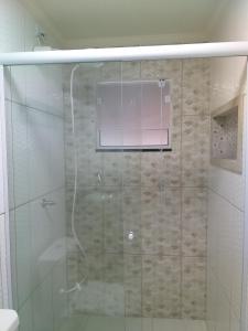 a shower with a glass door in a bathroom at Lar da Erica in Ubatuba