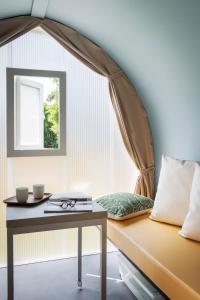 a room with a bed with a table and a window at International Glamping Lago Di Bracciano in Trevignano Romano