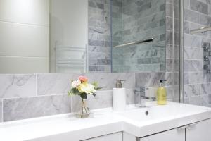 a white bathroom with a sink and a mirror at Reading Kings Road Lodge by Creatick Apartments in Reading