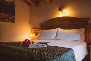 
a bed with a white comforter and pillows on it at Hotel Garnì La Soldanella in Madonna di Campiglio
