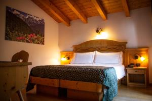
a bedroom with a bed and a lamp at Hotel Garnì La Soldanella in Madonna di Campiglio

