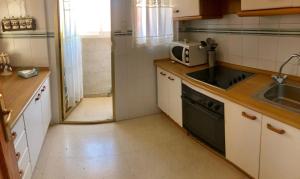 a kitchen with a sink and a microwave at Apartment In Poniente Beach in Benidorm
