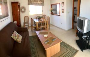 a living room with a couch and a tv and a table at Apartment In Poniente Beach in Benidorm