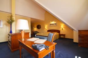 a hotel room with a bed and a desk with a lamp at Altstadthotel Bräuwirt in Weiden