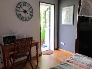 a room with a desk and a clock on the wall at Villa Saphir B & B in Sainte-Anne