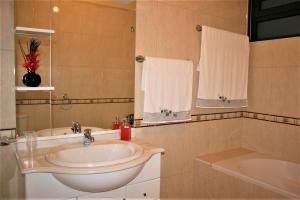 un baño con lavabo y bañera en The Rose House, en Arco da Calheta 17 fotos más