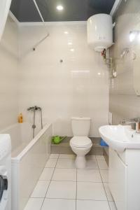 a white bathroom with a toilet and a sink at Cozy apartment in a new building close to the downtown in Kyiv