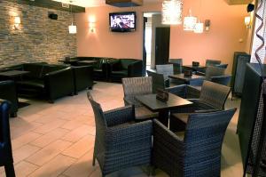 een restaurant met tafels en stoelen en een tv bij Penzion Siesta in Vráble