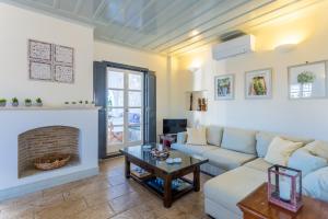 a living room with a couch and a fireplace at Villa Scirocco in Spetses